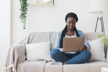 Woman sitting on couch using laptop