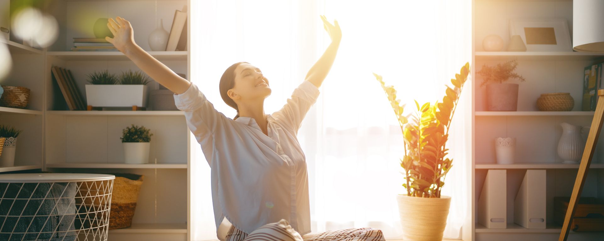 Portrait of a woman stretching her arms at home.