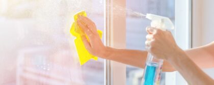 Hands with napkin cleaning window.