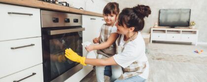 Mom and daughter cleaning their oven.