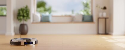 Robot vacuum on a wooden floor with a home lounge in the background