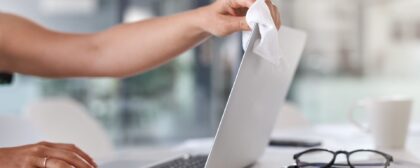 Close-up shot of a person cleaning their laptop screen.