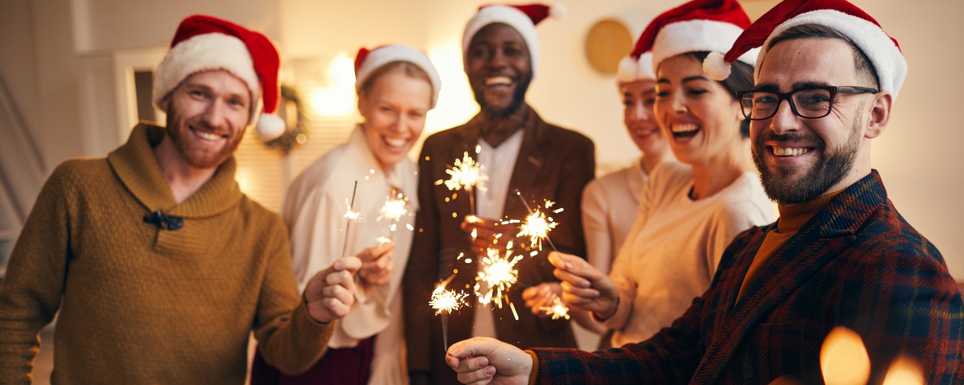 Friends at a party all holding sparklers