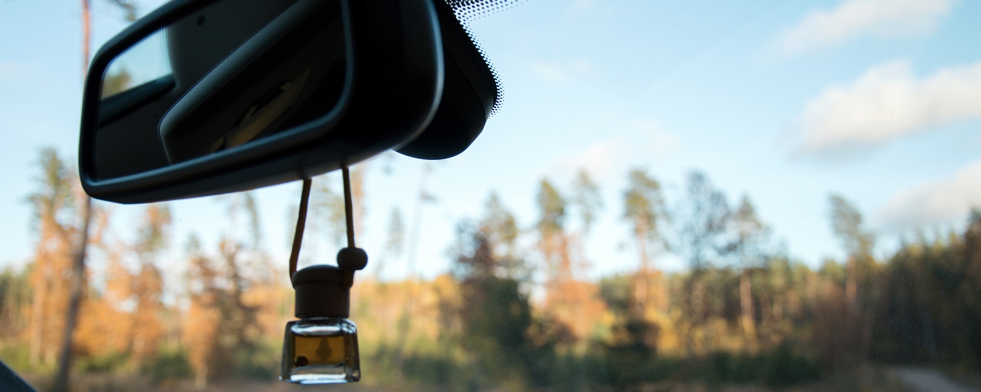 Car air freshener hanging off a car's rearview mirror