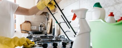 Close-up of a person wearing gloves and cleaning their stovetop