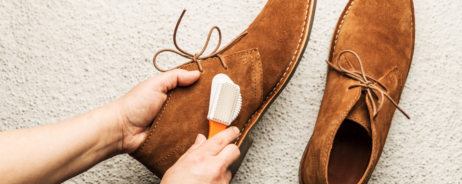 Close-up shot of a person brushing suede shoes